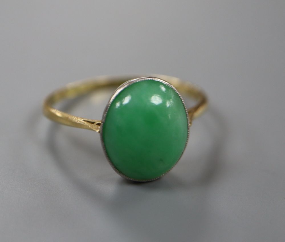 An 18ct and oval cabochon jade set ring, size Q, gross 2.8 grams.